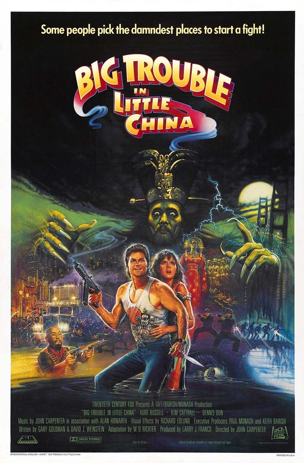 Original theatrical movie poster for Big Trouble in Little China, featuring Kurt Russell as Jack Burton holding a machine gun amidst chaos, mystic figures, and the looming face of Lo Pan.