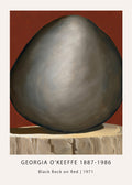 Georgia O'Keeffe oil painting, "Black Rock on Red" (1971), featuring a dark gray, smooth boulder against a vibrant terracotta background, resting on a textured base.