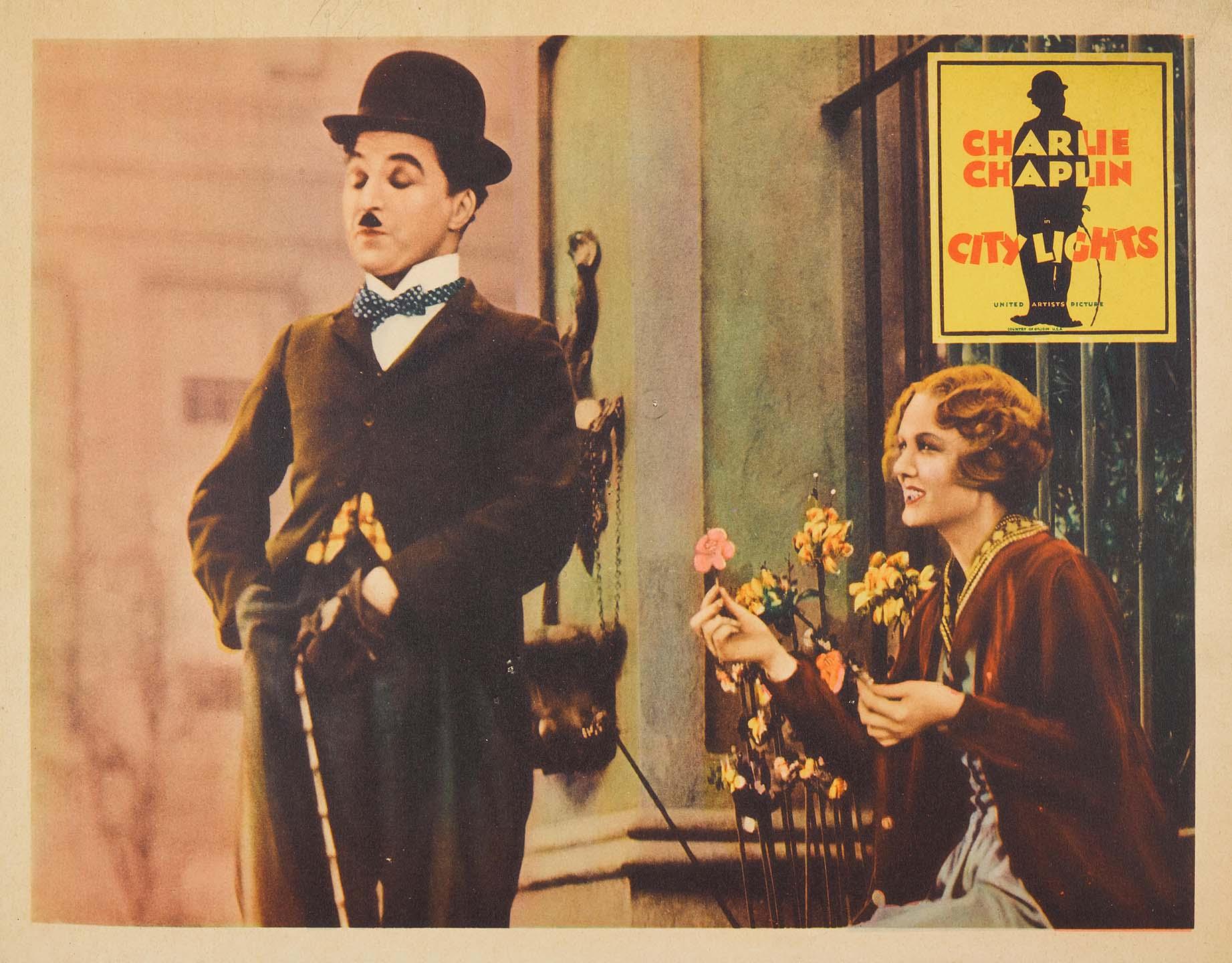 Lobby card for Charlie Chaplin's City Lights (1931) showing The Tramp looking at the blind Flower Girl who is holding a pink flower.