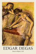 Reproduction of Edgar Degas's 1898 pastel drawing showing two ballet dancers resting, rendered in warm gold and brown tones.