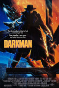 Original theatrical movie poster for Darkman (1990) showing the protagonist in a trench coat and fedora against a fiery orange skyline above a city.
