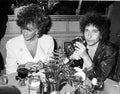 Black and white photo print showing Bob Dylan sitting at a table next to Elizabeth Taylor in 1986