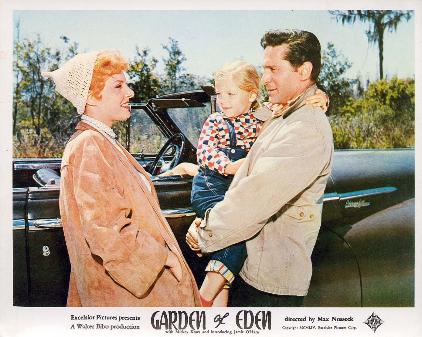 Vintage lobby card for the 1954 movie Garden of Eden, showing a man holding a child next to a woman and a convertible car.