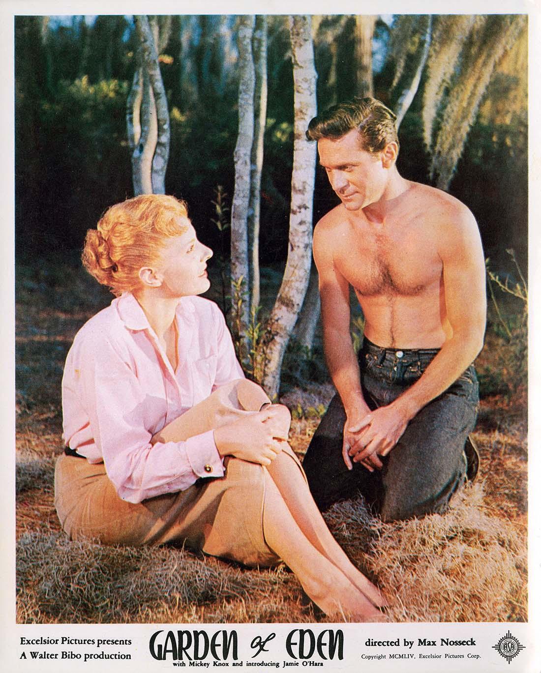 Vintage lobby card featuring a scene from the 1954 film Garden of Eden, showing Mickey Knox and Jamie O'Hara sitting outdoors in a forest setting.