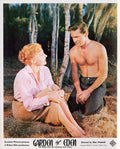 Vintage lobby card replica for the 1954 film Garden of Eden, showing a man and woman kneeling in a lush, wooded environment.