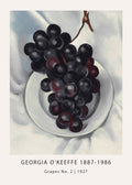 Georgia O'Keeffe's painting of dark purple grapes on a white plate, showing modernist still life composition and rich texture.