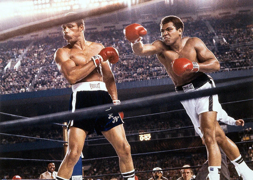 Color photo capturing Muhammad Ali in white shorts throwing a powerful right punch at Ken Norton during an intense professional boxing match.