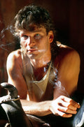 Close-up portrait of Patrick Swayze as Dalton from Road House, wearing a tank top with smoke curling around his face in dramatic lighting.