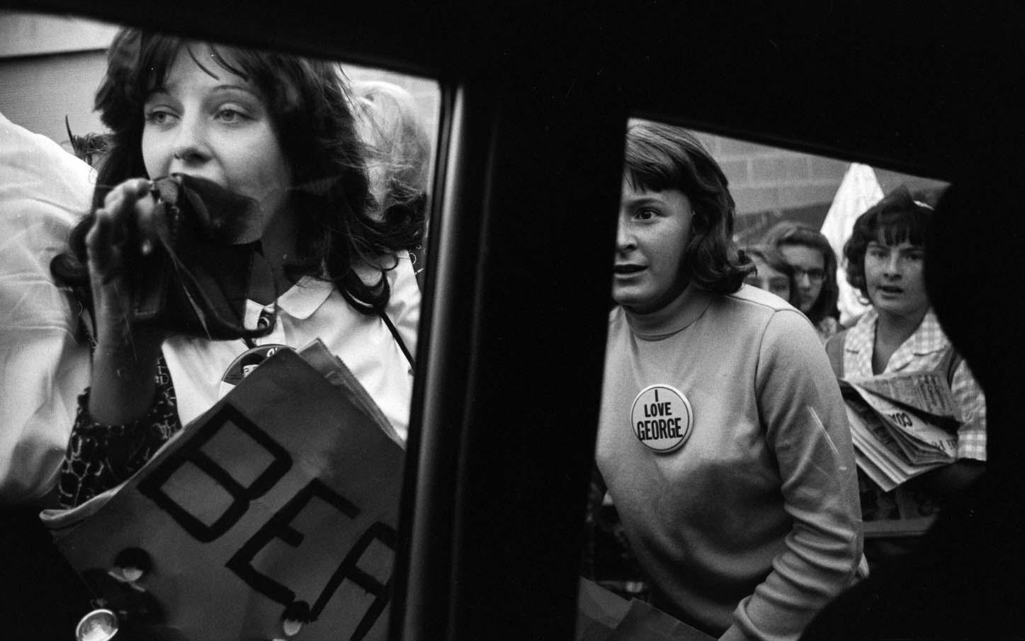 Emotional fans, one wearing an 'I Love George' pin, reacting intensely during The Beatles 1964 U.S. tour photo print.