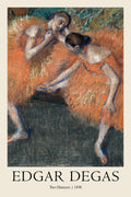 Edgar Degas' 1898 pastel painting, "Two Dancers," featuring two ballerinas in vibrant orange tutus against a dark, moody background.