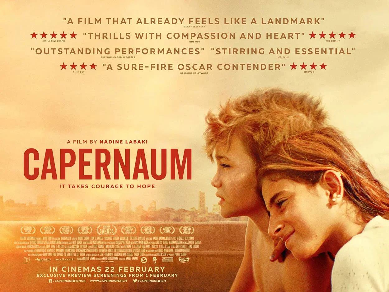 Official poster for the 2018 Lebanese drama Capernaum featuring the lead child actor Zain Al Rafeea and a co-star against a sunset cityscape, displaying critical review quotes.