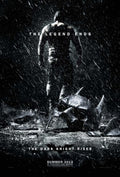 The Dark Knight Rises poster showing the imposing, shirtless silhouette of Bane walking away from a shattered Batman cowl in the pouring rain.