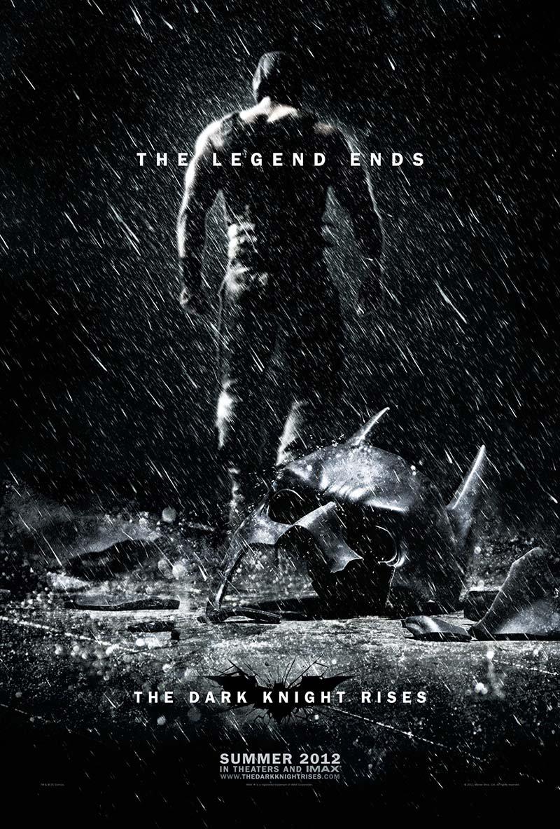 The Dark Knight Rises poster showing the imposing, shirtless silhouette of Bane walking away from a shattered Batman cowl in the pouring rain.