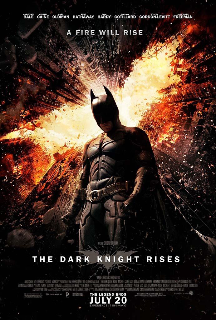 Official poster for The Dark Knight Rises showing Batman standing in the foreground as Gotham City explodes in flames behind him.