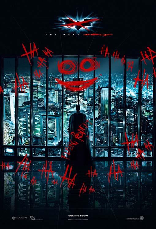 The Dark Knight movie poster showing Batman standing in silhouette against a skyscraper window covered in red Joker graffiti and the Gotham city skyline.