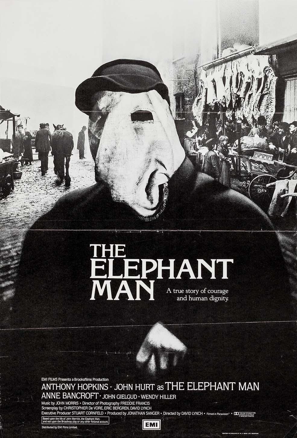Black and white movie poster for The Elephant Man (1980) showing John Hurt's character, John Merrick, wearing a covering sack over his head in a crowded Victorian street market.